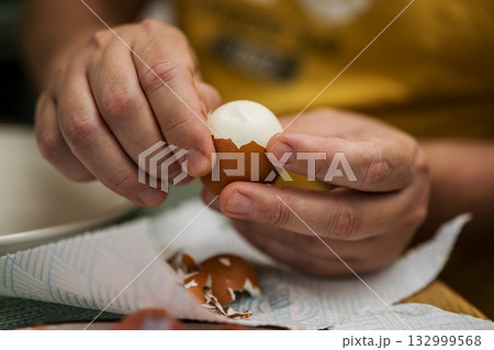 Boiled eggs for breakfast. Man remove eggshells, boiled egg. Eating proteins Boiled eggs for breakfast. Man remove eggshells, boiled egg. Eating proteins 132999568