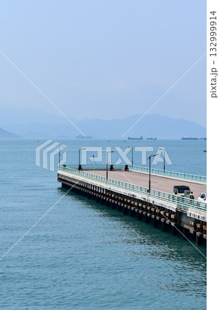 The pier at Tsim Sha Tsui, Hong Kong in the sunny day. Travel and nature scene. Seascape in Hong Kong. Sea background. The pier at Tsim Sha Tsui, Hong Kong in the sunny day. Travel and nature scene. Seascape in Hong Kong. Sea background. 132999914