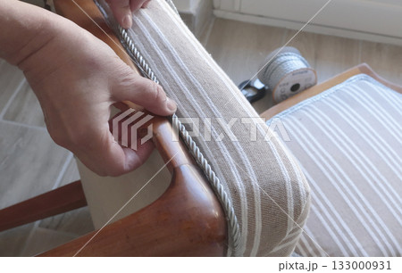 Anonymous person glues decorative braid. Antique furniture restoration. Crafts and hobbies. 133000931