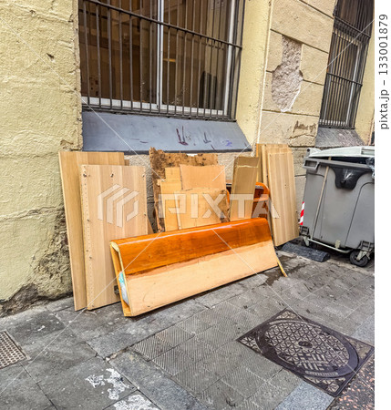 Discarded Wooden Furniture and Boards Left Beside Building Wall 133001879