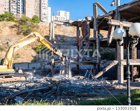 demolition excavator dismantles concrete building demolition excavator dismantles concrete building 133001918