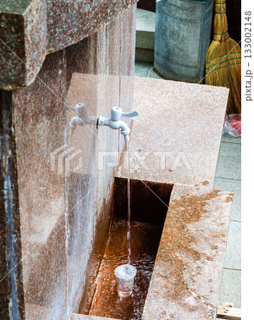 hot natural mineral water fills glass in Borjomi 133002148