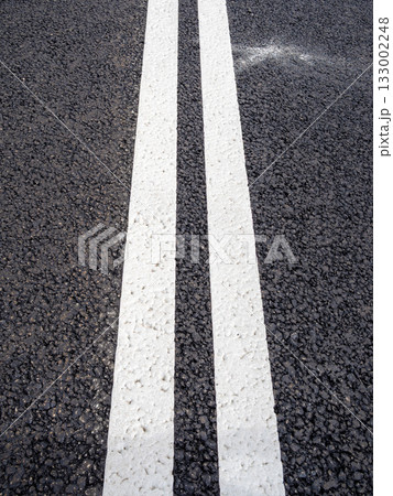 white double solid line on new asphalt surface 133002248