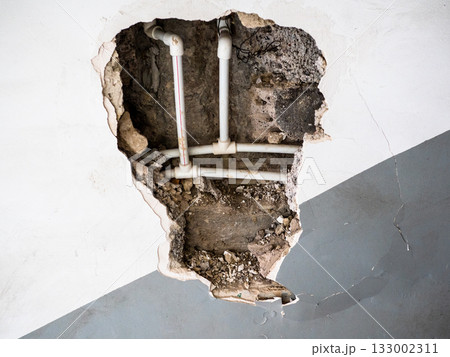 view of new plastic water pipes in broken wall 133002311