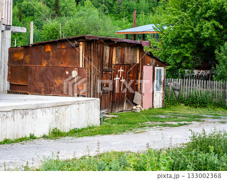 rusty barn with crosses painted on door on street 133002368