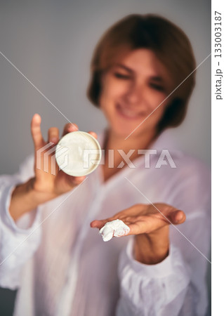 Woman holding skincare cream for beauty routine 133003187