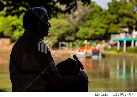 Senior woman at the Ronda del Sinu walking path along the river bank in the city of Monteria Colombia Senior woman at the Ronda del Sinu walking path along the river bank in the city of Monteria Colombia 133003407