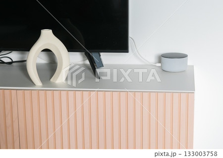 Abstract vase near television. Interior calm, visual harmony, and balance between art and technology. 133003758