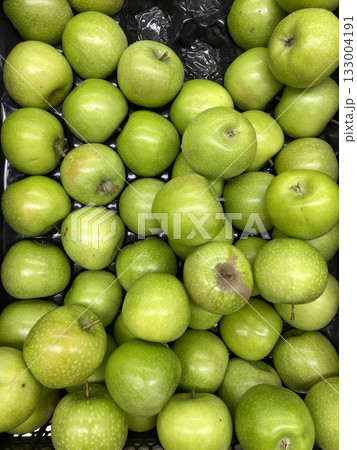 Green apples stacked in abundance, showcasing fresh produce and healthy eating concepts Green apples stacked in abundance, showcasing fresh produce and healthy eating concepts 133004191