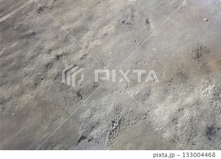 クレーターのような凹凸を持つザラザラとした砂地の表面の抽象的なグレーの背景 133004468