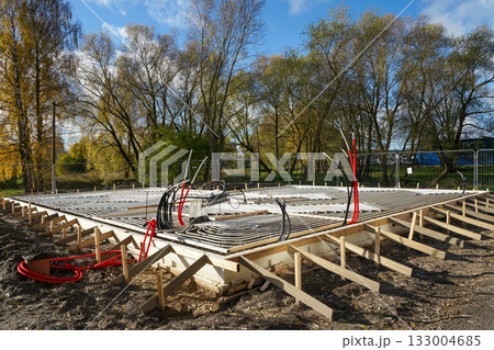 Underfloor heating system installation with plastic pipes in concrete base, house construction site Underfloor heating system installation with plastic pipes in concrete base, house construction site 133004685