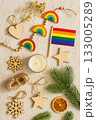 Festive Christmas Pride Flat Lay with Rainbow Ornaments, Pinecones, and Candles 133005289