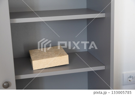 Closed beige photo album on gray shelf. Nostalgia, minimalism, and preserved memories in calm home interior. Closed beige photo album on gray shelf. Nostalgia, minimalism, and preserved memories in calm home interior. 133005785