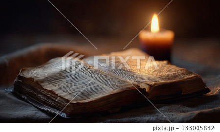 Ancient Bible on table with warm candle glow Ancient Bible on table with warm candle glow 133005832