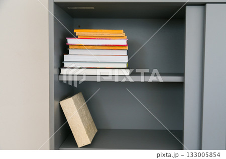 Stack of colorful books on shelf. Knowledge, curiosity, and personal growth within everyday living space. Stack of colorful books on shelf. Knowledge, curiosity, and personal growth within everyday living space. 133005854