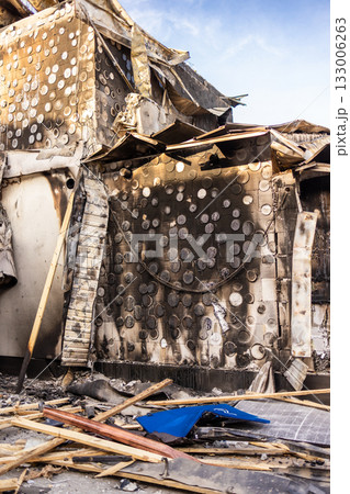 War. The aftermath of Russian airstrikes on a peaceful Ukrainian city. A hospital and a recreation center were destroyed. Charred wall with circular burn marks and debris from fire damaged building. War. The aftermath of Russian airstrikes on a peaceful Ukrainian city. A hospital and a recreation center were destroyed. Charred wall with circular burn marks and debris from fire damaged building. 133006263