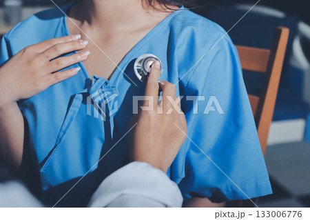 healthy concept; Doctor checking patient's heart with stethoscope at a hospital healthy concept; Doctor checking patient's heart with stethoscope at a hospital 133006776