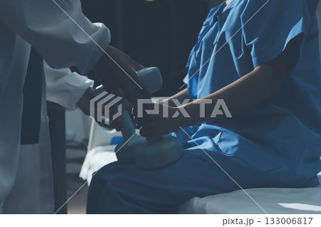 Physical therapist assisting a woman with dumbbell exercise 133006817