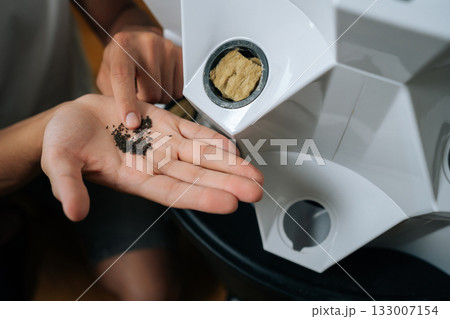 Gardener hand holding tiny seeds, preparing planting into hydroponic tower system with rockwool substrate, highlighting innovative agricultural growing technique. Concept of urban farming. Gardener hand holding tiny seeds, preparing planting into hydroponic tower system with rockwool substrate, highlighting innovative agricultural growing technique. Concept of urban farming. 133007154