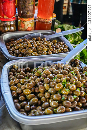 Close-up of two bowls filled with marinated green and black olives displayed at a market. Highlights natural texture and vibrant colors. Ideal for food photography, Mediterranean cuisine, healthy Close-up of two bowls filled with marinated green and black olives displayed at a market. Highlights natural texture and vibrant colors. Ideal for food photography, Mediterranean cuisine, healthy 133007195