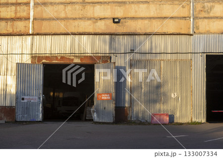 Old garage or warehouse with open gates in an industrial building 133007334