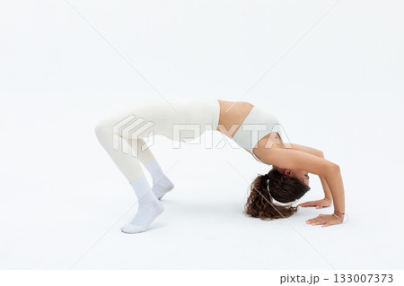 Fitness pose showcase, Elegant woman balances gracefully, Athlete demonstrating flexibility and strength wih focus, Dancer in white attire performing bridge with poise Fitness pose showcase, Elegant woman balances gracefully, Athlete demonstrating flexibility and strength wih focus, Dancer in white attire performing bridge with poise 133007373