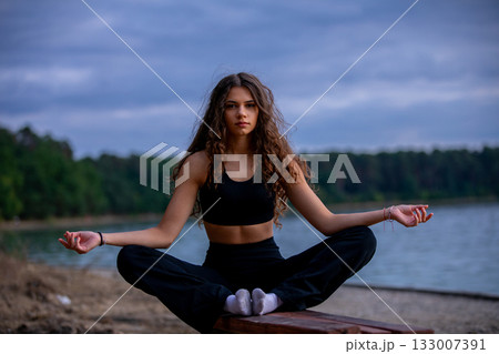 Meditation at Sunset by the Lake Enjoying Serene and Peaceful Vibes in Natures Embrace 133007391