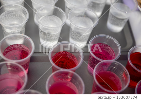 A Variety of Colorful Party Drinks Served in Plastic Cups on a Tray for Everyone to Enjoy A Variety of Colorful Party Drinks Served in Plastic Cups on a Tray for Everyone to Enjoy 133007574