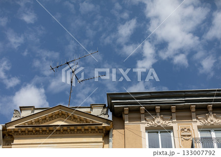 Antennas are prominently displayed on a Historic Building against a backdrop of a clear blue sky 133007792