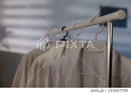 A Stylish Garment Rack that beautifully displays a variety of Neutral Toned Clothing Items 133007799
