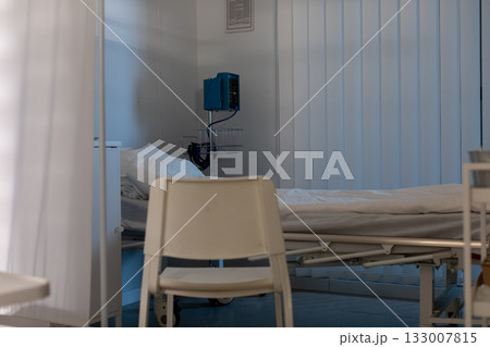 A minimal hospital room with a bed and essential medical equipment elegantly arranged 133007815