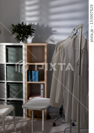 A beautifully designed minimalist medical room with garments and shelving for optimal efficiency 133007829