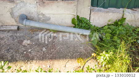 Downspout pipe by house wall home maintenance scene 133010012