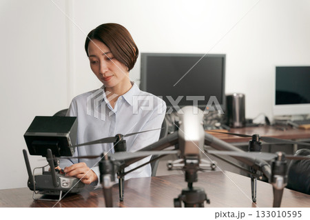 ドローンの操作確認をする女性 133010595