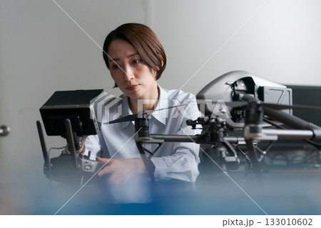 ドローンの操作確認をする女性 ドローンの操作確認をする女性 133010602