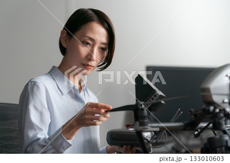 ドローンの操作確認をする女性 ドローンの操作確認をする女性 133010603