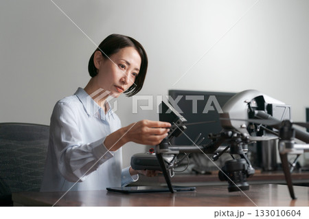 ドローンの操作確認をする女性 133010604