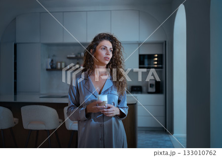 Young woman in pajamas having coffee in modern Young woman in pajamas having coffee in modern 133010762