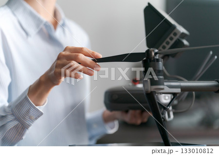 ドローンの操作をする人の手元 133010812