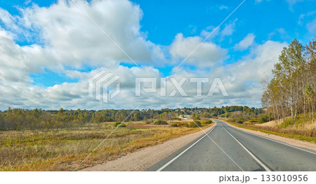 Country road through fields and forest cloudy day freedom of the road horizontal frame Country road through fields and forest cloudy day freedom of the road horizontal frame 133010956