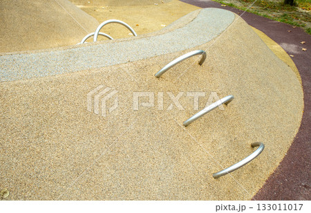 Play hill with metal climbing arches, safe rubber surfacing in park 133011017