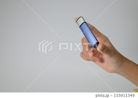 USBメモリを掴む手のクローズアップ 133011349