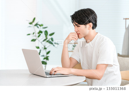 家のリビングでノートパソコンを使う若いアジア人男性（投資,ショック,トラブル,下落,リスク） 133011368