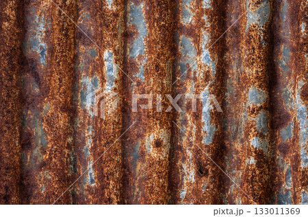 An old rusty metal sheet roof textured. Rust is an iron oxide formed by the reaction of iron and oxygen in the catalytic presence of water or air moisture. An old rusty metal sheet roof textured. Rust is an iron oxide formed by the reaction of iron and oxygen in the catalytic presence of water or air moisture. 133011369