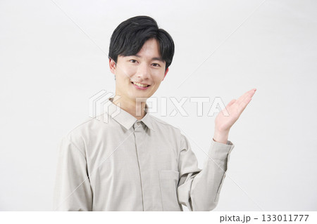 手のひらで右側を指す男性 20代 白背景 手のひらで右側を指す男性 20代 白背景 133011777