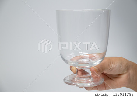 透明な脚付きグラスを持つ手 透明な脚付きグラスを持つ手 133011785