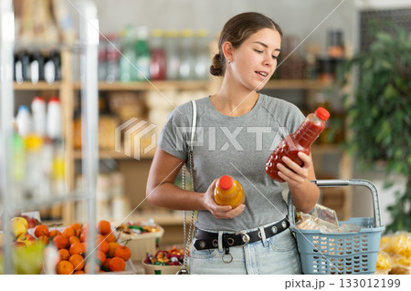 Woman choosing juice in supermarket 133012199