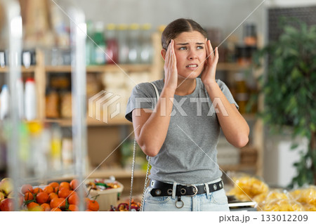Young woman with headache in grocery store 133012209