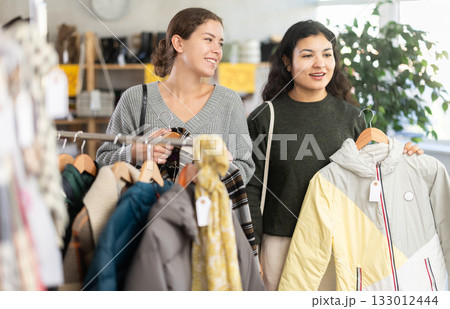 Two women choosing jackets in a clothing store 133012444