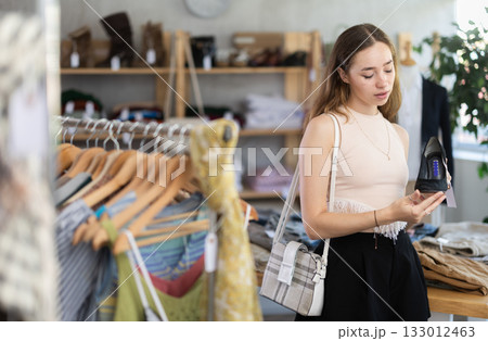 Young woman choosing heels in clothing store 133012463